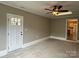 Bonus room with carpet and doorway leading to kitchen; features ceiling fan and door to exterior at 4402 Poxon Ln, Monroe, NC 28110