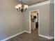 Dining room displaying neutral walls, modern chandelier, and doorway to the kitchen at 4402 Poxon Ln, Monroe, NC 28110