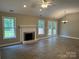 Spacious living room with brick fireplace, wood-look flooring, and vaulted ceiling with ceiling fan at 4402 Poxon Ln, Monroe, NC 28110