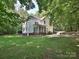 Back exterior of home with a screened in porch, greenery, and an outdoor patio at 443 Hillcrest Dr, Harrisburg, NC 28075