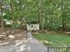 Backyard with gravel path leading to a white shed surrounded by lush trees at 443 Hillcrest Dr, Harrisburg, NC 28075