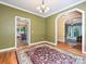 Dining room showcasing hardwood floors, large window, and connections to the kitchen and living areas at 443 Hillcrest Dr, Harrisburg, NC 28075