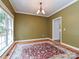 Dining room features hardwood floors, large window, and elegant chandelier, perfect for formal gatherings at 443 Hillcrest Dr, Harrisburg, NC 28075