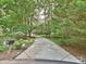Long driveway leading up to a brick home, surrounded by lush greenery at 443 Hillcrest Dr, Harrisburg, NC 28075