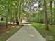 Long driveway leading up to a home surrounded by lush green trees and grass at 443 Hillcrest Dr, Harrisburg, NC 28075