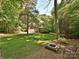 Beautiful yard and landscaping with a brick fire pit and an outdoor metal chair at 443 Hillcrest Dr, Harrisburg, NC 28075