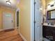 A hallway shows a white entry door leading past a powder room with dark fixtures at 443 Hillcrest Dr, Harrisburg, NC 28075