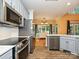 Modern kitchen with stainless steel appliances, gray cabinetry, and view into the backyard at 443 Hillcrest Dr, Harrisburg, NC 28075