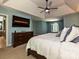 Well-lit main bedroom with tray ceilings, a mounted TV, and an adjacent bathroom at 443 Hillcrest Dr, Harrisburg, NC 28075