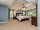 Spacious main bedroom with tray ceilings, large windows, and neutral carpeting at 443 Hillcrest Dr, Harrisburg, NC 28075