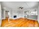 Inviting living room with a cozy fireplace and hardwood floors, open to kitchen, and a ceiling fan at 514 Jones St, Chester, SC 29706
