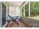 Screened porch with tile flooring, chair, side table, and view of trees at 5141 Grandview Dr, Fort Mill, SC 29707
