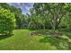 The lush lawn is complete with a bird bath and manicured trees at 5211 Londonderry Rd, Charlotte, NC 28210