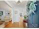 Inviting home foyer with hardwood floors, art, and decoratively trimmed passageways into the living room and kitchen at 5211 Londonderry Rd, Charlotte, NC 28210