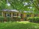 Charming brick home with a well-manicured lawn, classic shutters, and inviting front porch with an American flag at 5211 Londonderry Rd, Charlotte, NC 28210