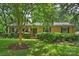 Charming brick home with a well-manicured lawn, classic shutters, and inviting front porch with an American flag at 5211 Londonderry Rd, Charlotte, NC 28210