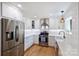Updated kitchen featuring stainless steel appliances, white cabinets, hardwood floors, and modern fixtures at 5211 Londonderry Rd, Charlotte, NC 28210