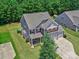 Aerial view of a two-story home with a three-car garage, mature trees, and a well-kept lawn at 5797 Mcclintock Dr, Denver, NC 28037