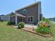Exterior view of home with a covered patio, landscaped yard, and vibrant flowerbeds at 5797 Mcclintock Dr, Denver, NC 28037
