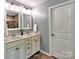 Bathroom with double sink vanity and storage, featuring a white door and neutral wall color at 5797 Mcclintock Dr, Denver, NC 28037