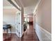 Elegant hallway with hardwood floors, white wainscoting, and a view of the living spaces at 5797 Mcclintock Dr, Denver, NC 28037