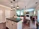 Open kitchen with island seating, stainless steel appliances, and view to dining area and living room at 5797 Mcclintock Dr, Denver, NC 28037