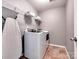 Laundry room with modern front load washer and dryer, shelving, and ironing board at 5797 Mcclintock Dr, Denver, NC 28037