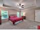Spacious primary bedroom with tray ceiling, ceiling fan, and natural light at 5797 Mcclintock Dr, Denver, NC 28037
