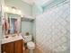 Bathroom with a neutral-toned shower curtain and a wooden vanity at 6523 Alba Rose Ln, Huntersville, NC 28078