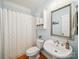 Cozy full bathroom with a pedestal sink, toilet, and shower with curtain at 6523 Alba Rose Ln, Huntersville, NC 28078
