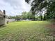 Expansive backyard with lush lawn, mature trees, and a partially fenced perimeter, perfect for outdoor activities at 6539 Louglen Cir, Charlotte, NC 28212
