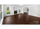 Spacious living room featuring dark wood floors, a cozy fireplace, and large windows at 745 Erin Brook Ct, York, SC 29745