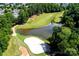 Scenic aerial view of a lush golf course, green, and a large pond at 8538 Highland Glen Dr, Charlotte, NC 28269