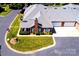 Aerial shot of a brick home with manicured lawn, screened porch, attached garage, and pristine gray roof at 8538 Highland Glen Dr, Charlotte, NC 28269