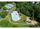 Aerial view showcasing a pool, tennis courts, and playground surrounded by lush trees at 8538 Highland Glen Dr, Charlotte, NC 28269