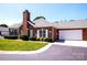 Charming brick home with attached garage, well-manicured lawn, and a classic chimney against a blue sky at 8538 Highland Glen Dr, Charlotte, NC 28269