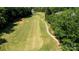 A lush green golf course fairway with a sand trap and winding cart path surrounded by mature trees at 8538 Highland Glen Dr, Charlotte, NC 28269