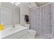 Bright bathroom featuring a white sink, toilet, and a shower with a patterned curtain at 10043 Elsenham Ln, Charlotte, NC 28269