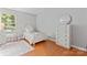 Charming bedroom with white furniture, including bed, dresser, desk and a round mirror at 10043 Elsenham Ln, Charlotte, NC 28269