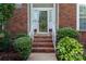 Inviting brick entrance with stairs, potted plants, and sidelights, showcasing a warm arrival at 10043 Elsenham Ln, Charlotte, NC 28269