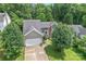 Charming home with a two-car garage, brick facade, an arched window, and mature trees at 10043 Elsenham Ln, Charlotte, NC 28269