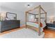 Spacious main bedroom showcasing a four-poster bed, wood floors, and a cozy, inviting atmosphere at 10043 Elsenham Ln, Charlotte, NC 28269