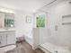 Bathroom featuring a glass shower, garden tub, single vanity, and ample natural light at 1008 Millbridge Pkwy, Waxhaw, NC 28173