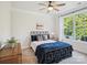 Charming bedroom featuring a metal frame bed, ceiling fan, and a bright window with a view to the backyard at 1008 Millbridge Pkwy, Waxhaw, NC 28173
