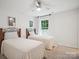Well-lit bedroom with neutral carpet, ceiling fan and two twin beds beneath a window at 1008 Millbridge Pkwy, Waxhaw, NC 28173