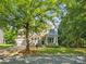 Charming two-story home with stone accents, a well-manicured lawn, and mature trees offering plenty of shade at 1008 Millbridge Pkwy, Waxhaw, NC 28173