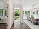 Bright foyer with hardwood floors leads to an elegant dining room with a stylish chandelier and abundant natural light at 1008 Millbridge Pkwy, Waxhaw, NC 28173