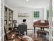 Well-lit home office with hardwood floors, a bookcase, and a piano, creating a comfortable workspace at 1008 Millbridge Pkwy, Waxhaw, NC 28173