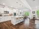Bright, open kitchen with an island, modern appliances, pendant lighting, and wood floors at 1008 Millbridge Pkwy, Waxhaw, NC 28173