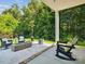Cozy covered patio with seating area and outdoor fireplace overlooking a lush backyard at 1008 Millbridge Pkwy, Waxhaw, NC 28173